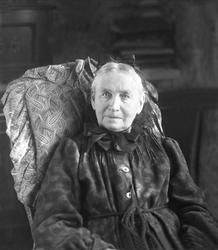 Portrett, eldre kvinne i svart, sittende. Fru Soot.