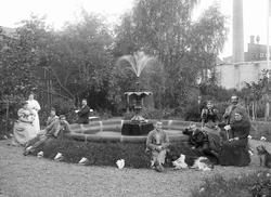 Fra kjøpmann Henriksens landsted. Familien samlet rundt font