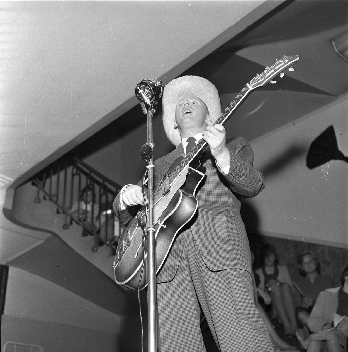 Arne Bendiksen synger og spiller. Moteoppvisning i varehuset Steen & Strøm, Kongens gate 23, Oslo, 28.10.1959.
