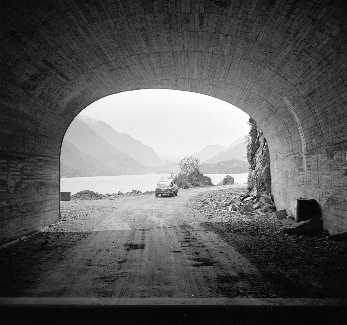 Sørfjorden i Hardanger, Hordaland, mai 1963. Bil på landevei, tunnel.
