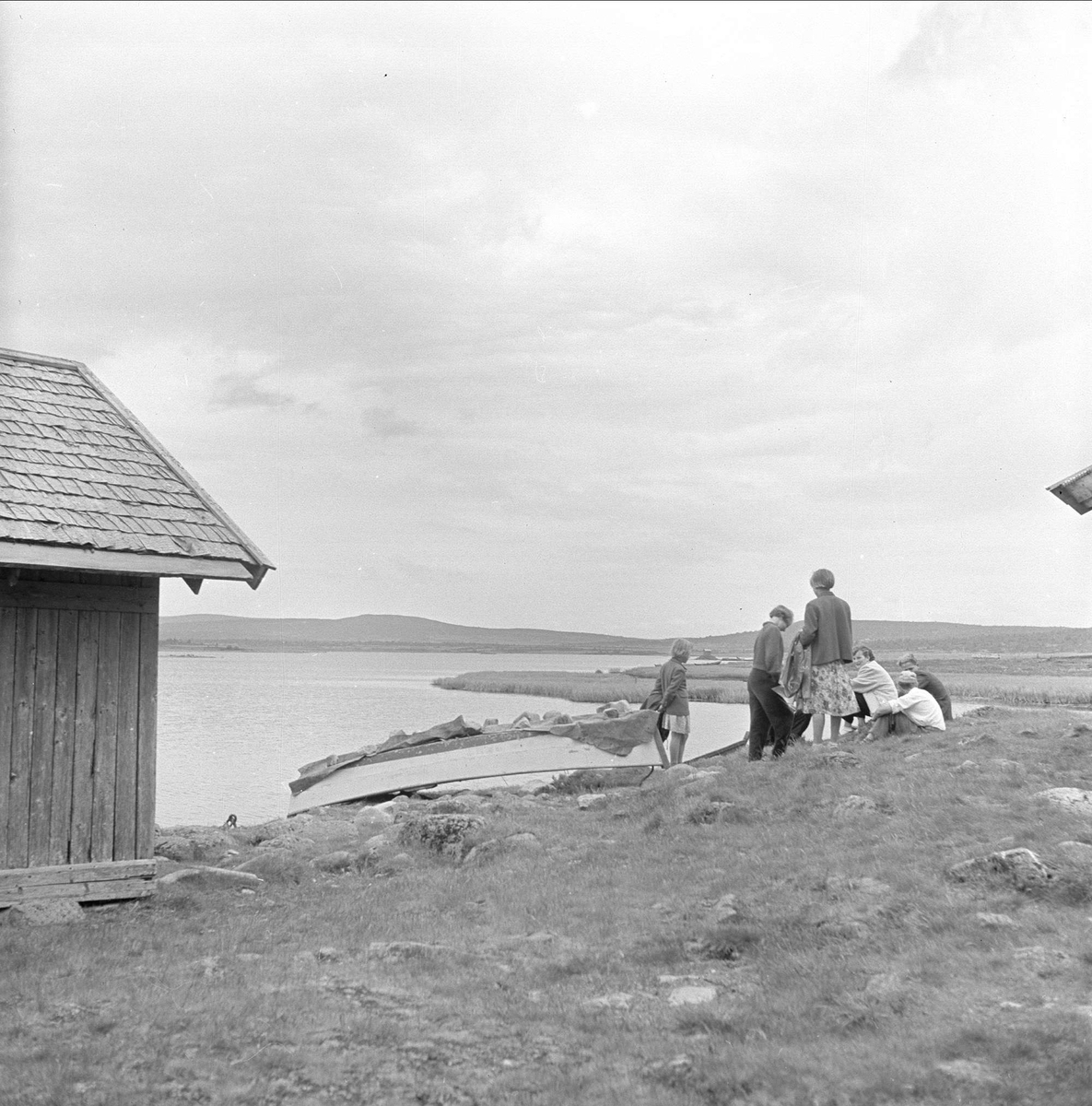 Sjusjøen, Ringsaker, Hedmark, juli 1954. Mennesker i fjellandskap. Vann, båter og buer.