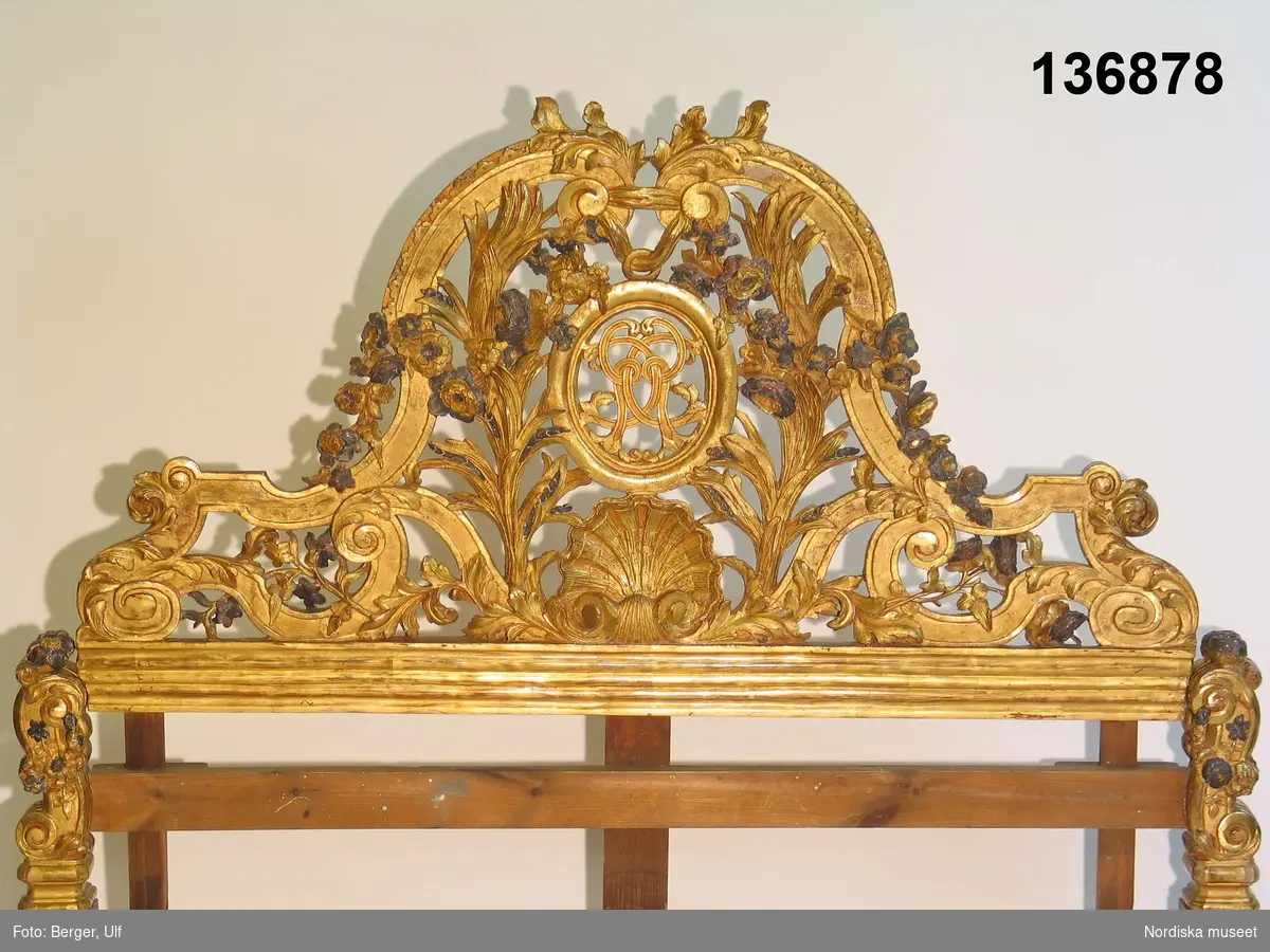 Huvudliggaren:
"Säng, himmelssäng, av förgyllt trä, rikt skulpterad. Till sängen höra 6 amoriner och 4 kronliknande prydnader. Å gaveln 'C G' i spegelmonogram. Till sängen gjordes 1919 järntenarna till himmeln. Tillhört Carl Gyllenstjerna (1649-1723) till Steninge.
Inköpt på Bukowskis konsthandel, auktion nr 188." (Rättelse: Bukowskis auktion nr 226, 28-29 september 1920, auktionsnr 188/Anna Womack 2007).
G. 30/9 1920 från Nordiska museets vänner."

Bilaga: 
Utdrag ur Bukowskis katalog: 
"188. Säng, tvåmans, i rikt skulpteradt och förg. trä. vid öfre ändan öfverstycke af bandornament med bladverk, blomsterguirlander, mussla och oval ram med monogram CG (=Carl Gustaf Gyllenstierna). Vid fotändan två upprätt sittande gripar, hållande små ornamenterade sköldar. Fötterna skulpterade i akantusmotiv. Sänghimmelstak bestående af tre skulpterade bågar, slutande i voluter och upptill brutna af akantusornament. På bågarna sex sittande putti i förg., svart och försilfradt trä. Fyra skulpterade krön i genombrutet arbete. Från Bogesunds slott. Tidigare å Steninge slott. I Buchard Preschts stil. Pl. [=Planch] 44."