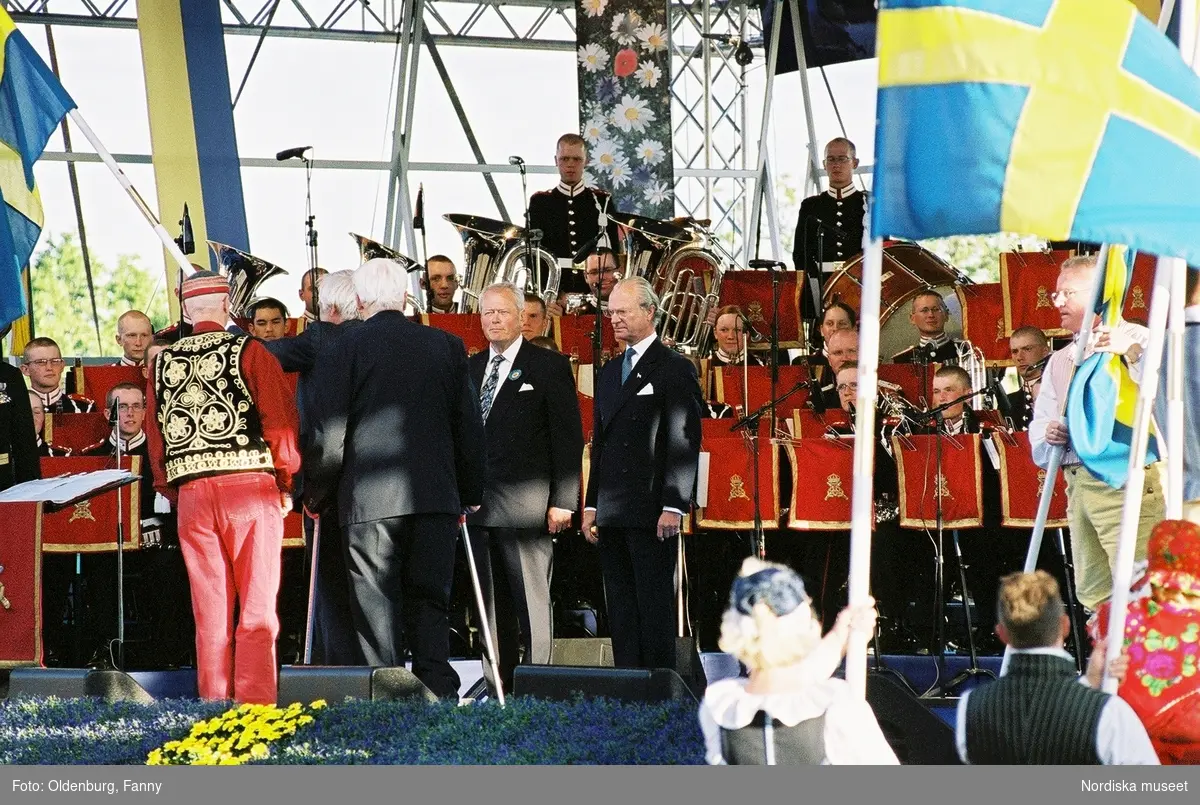 Firandet av den svenska nationaldagen den 6 juni 2004 på Skansen, Stockholm. Den kungliga familjen. Orkester. Publik. Artisterna Jan Malmsjö, Shirley Clamp, Magnus Carlsson.