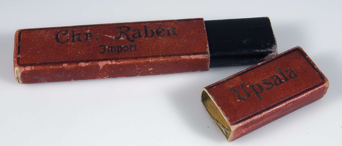 Rött fodral av papp med svart text: Chr. Rabén Import Uppsala.
