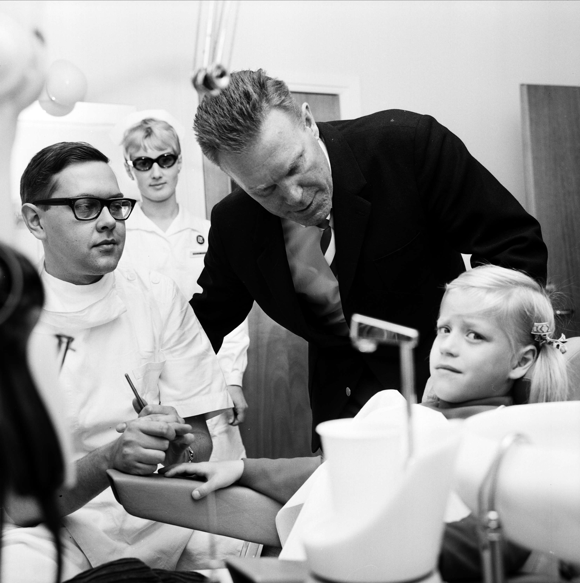 Linda Willén får sina tänder undersökta av tandläkare Nils Forsberg, medan landstingsrådet Ragnar Litzner och distriktstandsköterskan Inga-Lill Nordmark tittar på, den nya tandpolikliniken i Karlholmsbruk