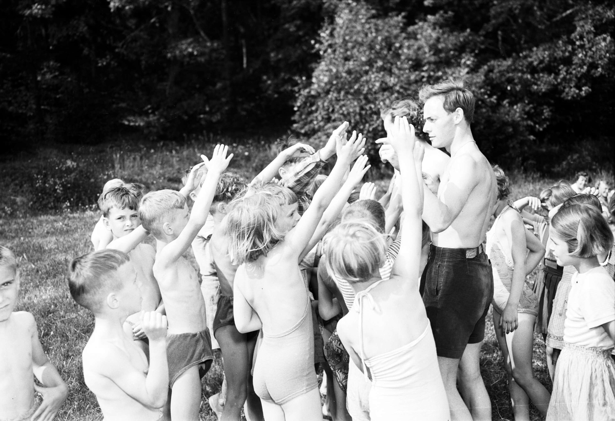 "Upsalasmåttingar på grönbete" - folkskollärare Gösta Hedengran med barn, Eda skollovskoloni, Lagga socken, Uppland juni 1954