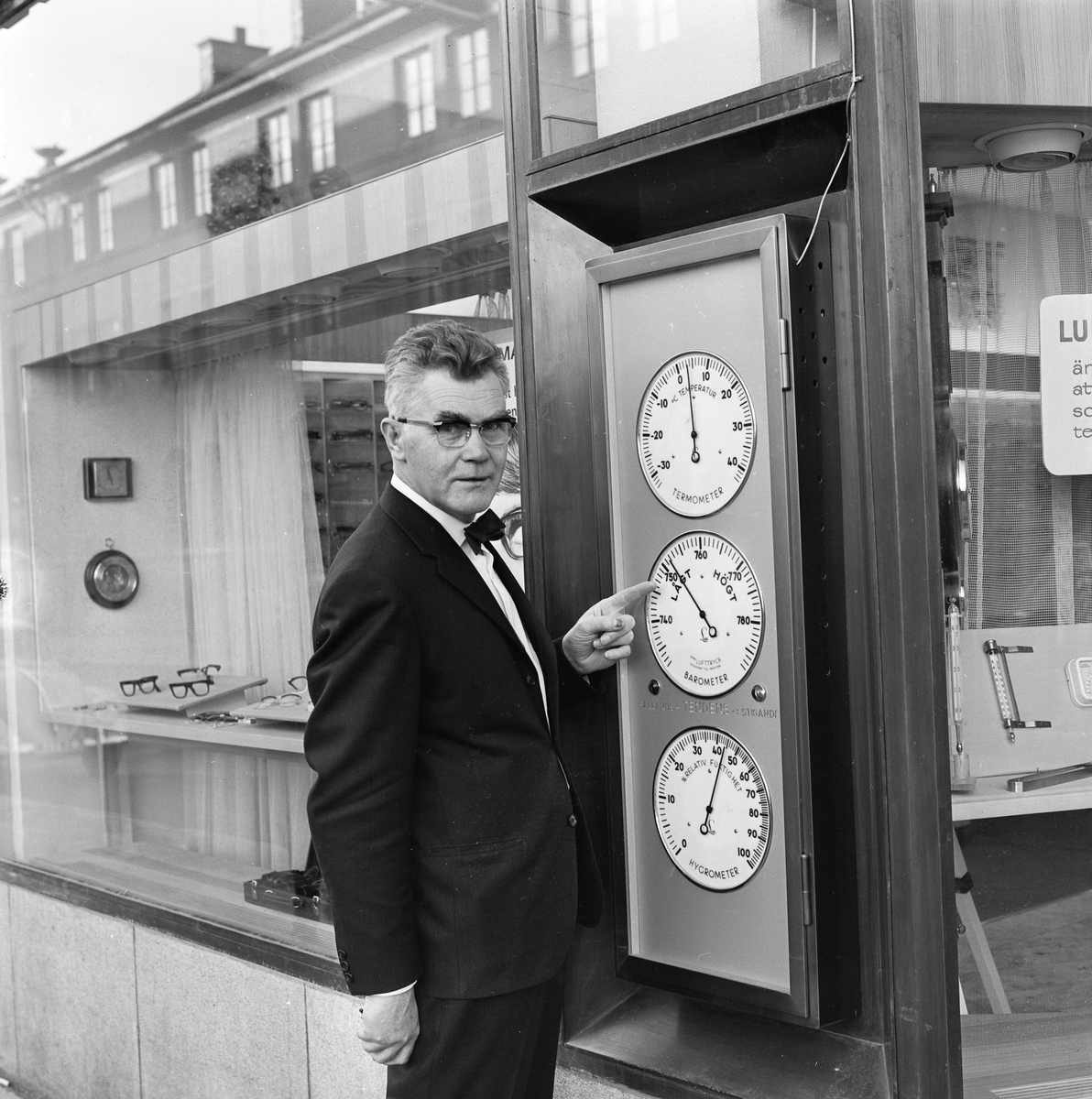 Ejnar Haglund vid skyltfönster till optikaffär, Uppsala 1965