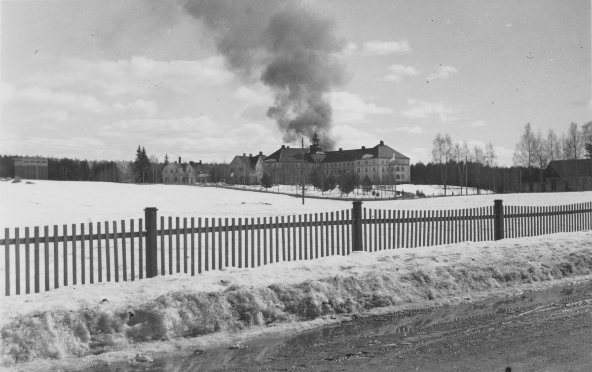 Røyksøyle bak Sentralsykehuset i Elverum etter bombenedslag på formiddagen 11. april 1940. 