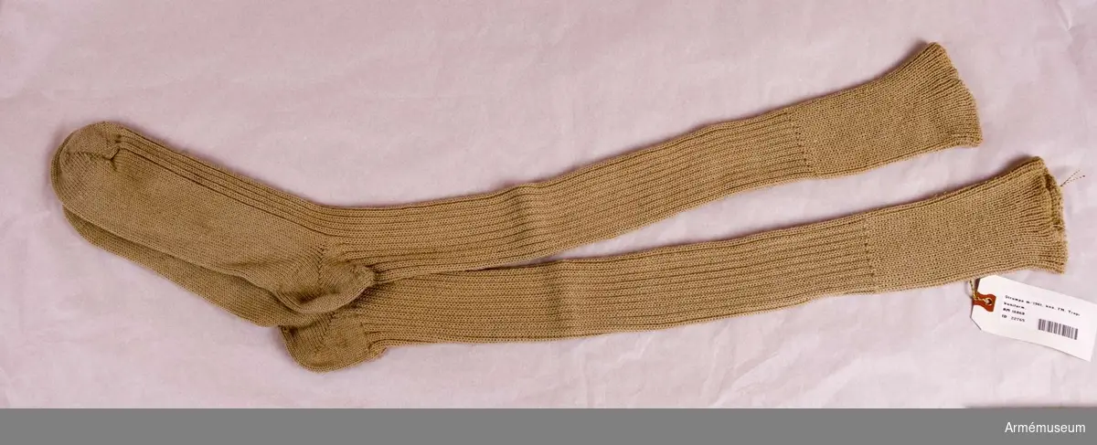 Knästrumpor m/1961 t tropikuniform. Stickade strumpor av beige yllegarn. Två räta, två aviga. Skall vikas ned under knäet.