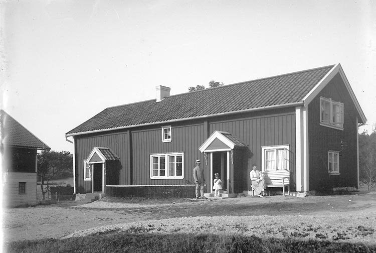 Enligt fotografens journal nr 4 1918-1922: "Gamlebergs gård L-a byggningen".
Familjen framför huset är; Artur Neuman, dottern Birgit, hustrun Signe med dottern Inga(född 1912) i knät