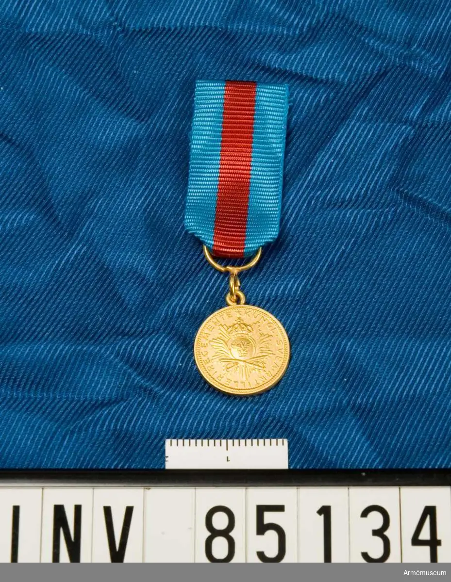 Medaljen är rund. Lilla riksvapnet ovanför två korsade sablar och överlagt ett strålknippe. Band kluvet i blått, rött och blått. Miniatyrmedaljen förvars i ask tillsammans med en medalj.