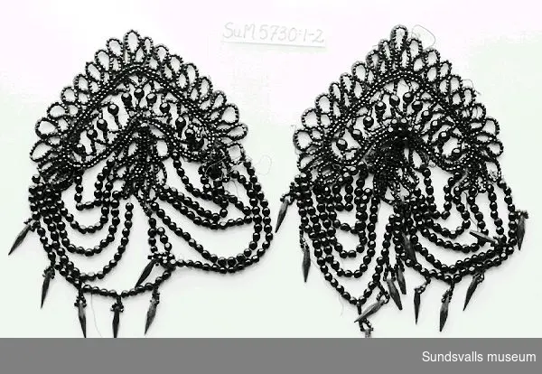 SuM 5730:1-2 två stycken pärlbroderade dräktdetaljer med svarta glaspärlor i olika former.