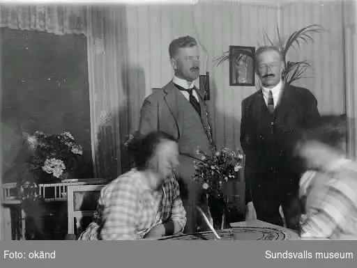 Bild 1: Förvaltare Waldemar Neuman (till vänster) och kassör August Nilsson vid Nya Söråkers sågverk. En av damerna är  fru Anna Neuman. Bilden är tagen i förvaltare Neumans matrum.