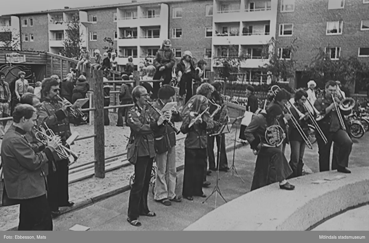 En inbjuden orkester från Norge spelar musik och mannen längst till vänster är Vicente Crespo. Bakom orkestern leker barn på lekplatsen. I bakgrunden ses personer som tittar på från sina balkonger. 1974 eller 1975.