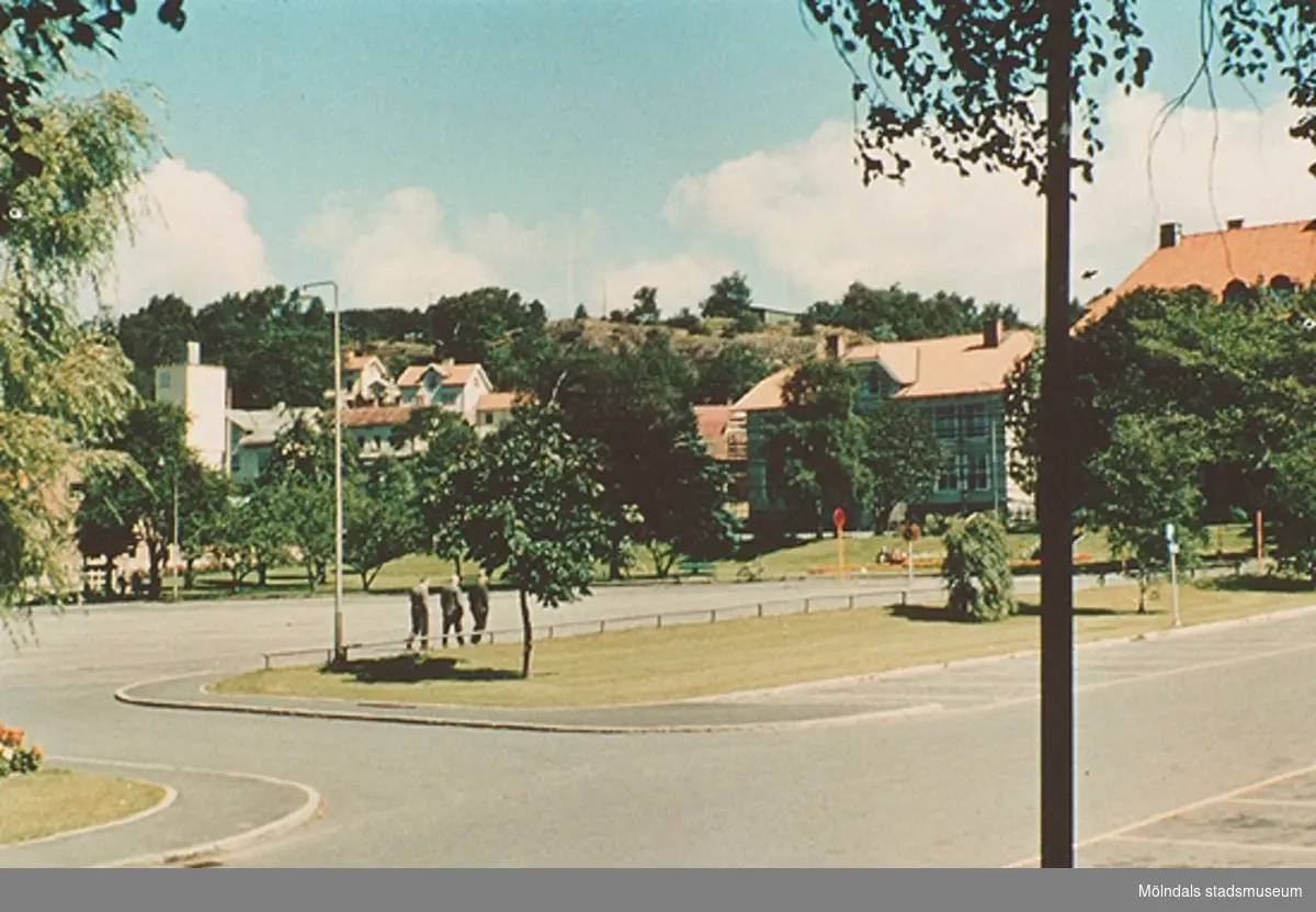 Från vänster ses brandstationen,Trädgårdsskolan och Kvarnbyskolan (bakom träden). 
Från utställningen; "Mölndals bro - minnen, förändring, framtid".