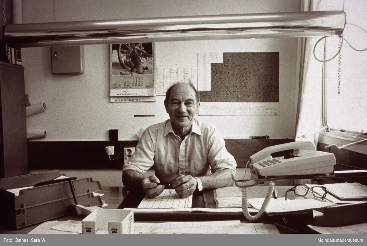 Skiftförman Erik Öberg sitter vid ett skrivbord på Papyrus i Mölndal, år 1990.