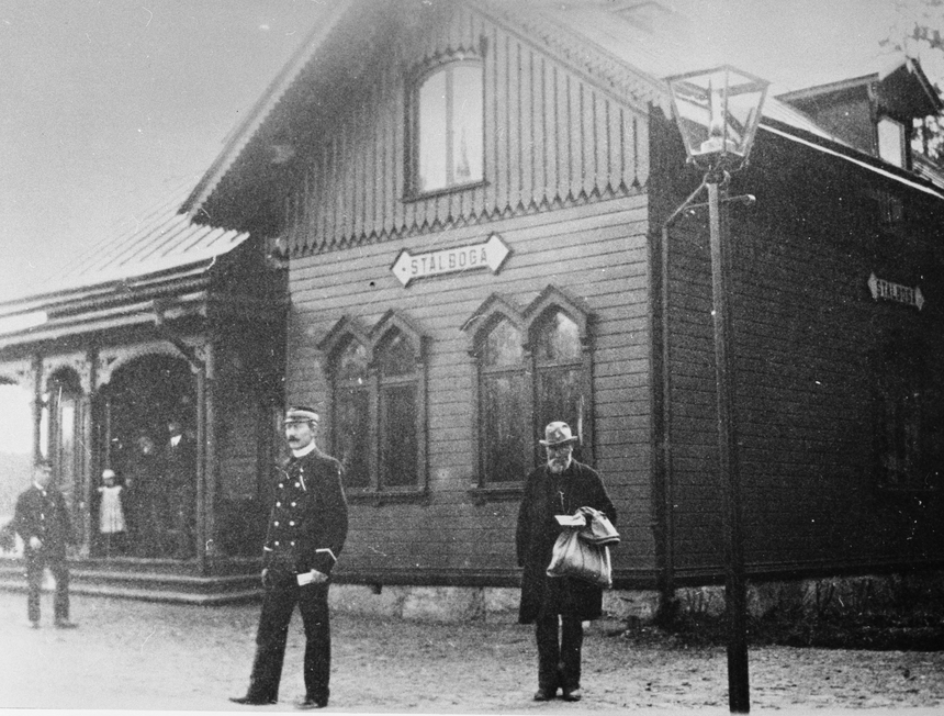 Postföraren Albert Forsberg längst till höger vid Stålboga järnvägsstation. Han bör ha varit i 60-årsåldern när fotot togs 1907. Två dagar i veckan gick Forsberg sin posttur i Dunker. Från Stenhammar i Dunkers socken gick han till Stålboga station för att hämta post. Han gick runt sjön Skundern och lämnade post i Smedsta, Ekeby, Mälby, Bråhovda och andra byar.