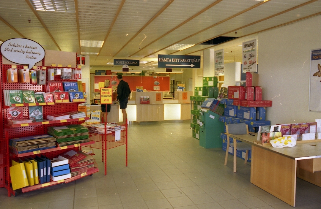Allmänhetens avdelning på regionpostkontoret Kungshörnet i Uppsala, 1996. I öppna säljmontrar på golvet utbjuds kuvert, paketkartonger och kontorsmaterial mm.