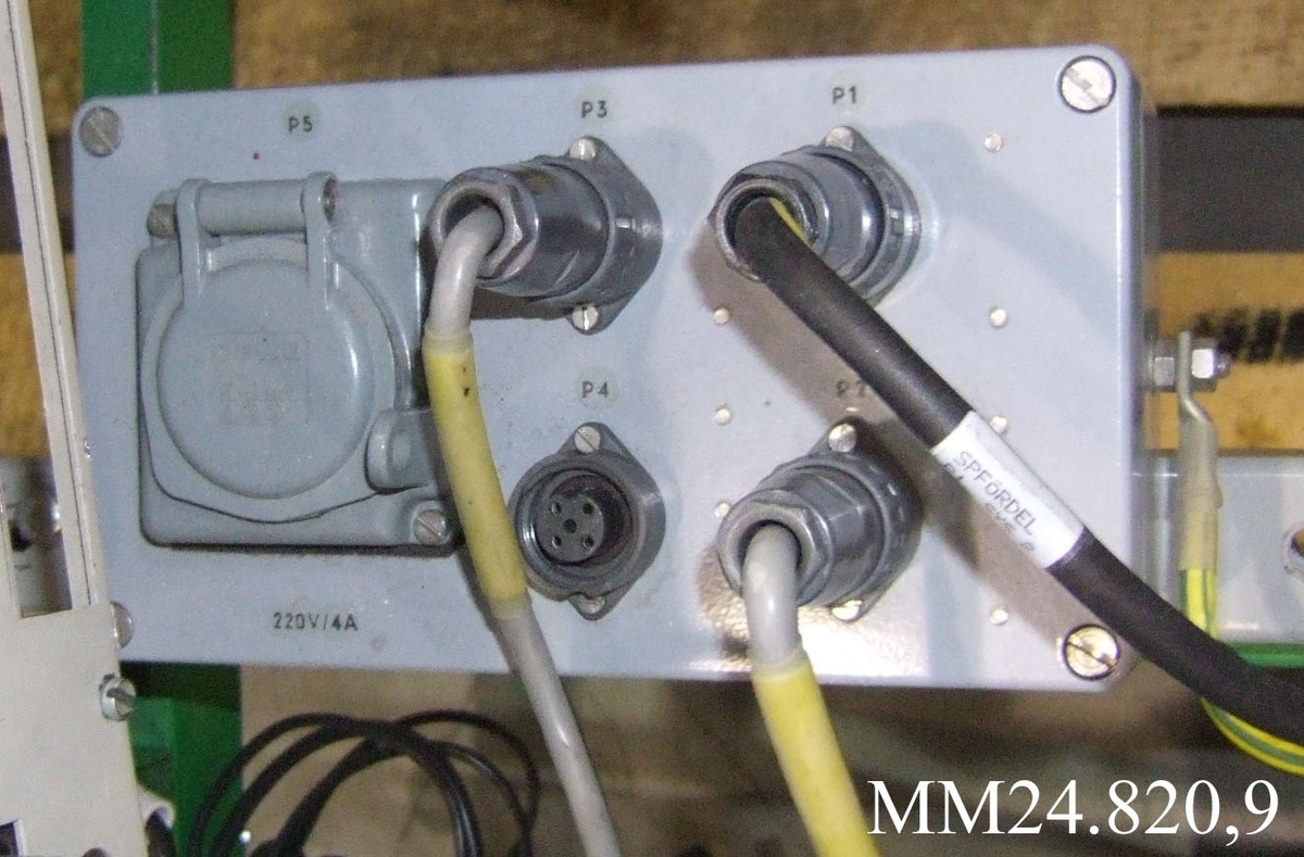 Grå kopplingsdosa med fyra ingångar för kablar samt uttag för ström under lock.