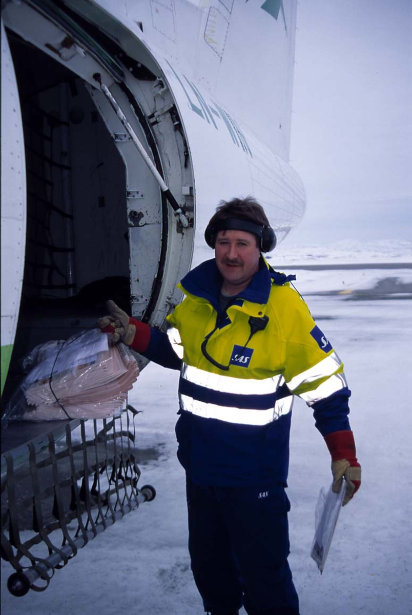 Lufthavn. 1 person som losser fra et fly, 1 DHC-8-103B LN-WIN "Lofoten" fra Widerøe.