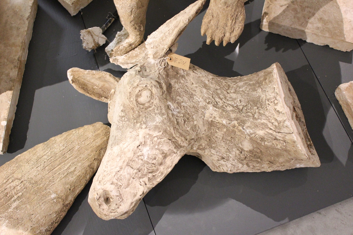 Skulptur i gips av et hjortedyr i bevegelse. Hode, bein og horn. Tittel: "Storebror"
Kanskje orginalen til hjortebukken i Studenterlunden?