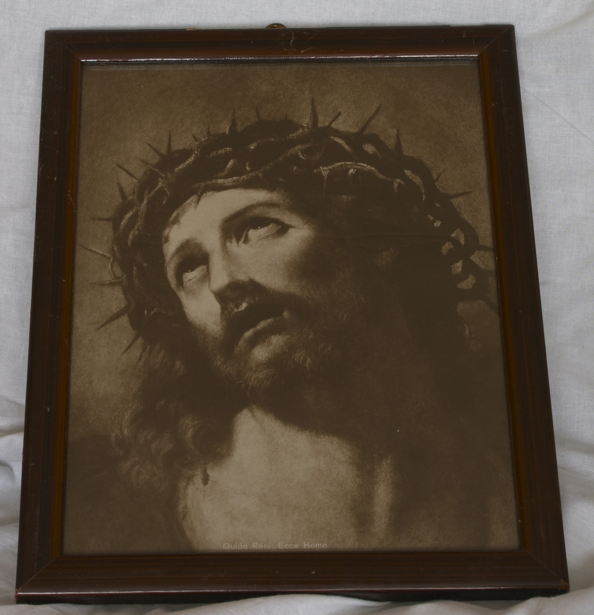 Bilde av Jesus med tornekrone. Smal enkel malt brun ramme i tre. Bildet er merket med: Guido Reni: Ecce Homo.