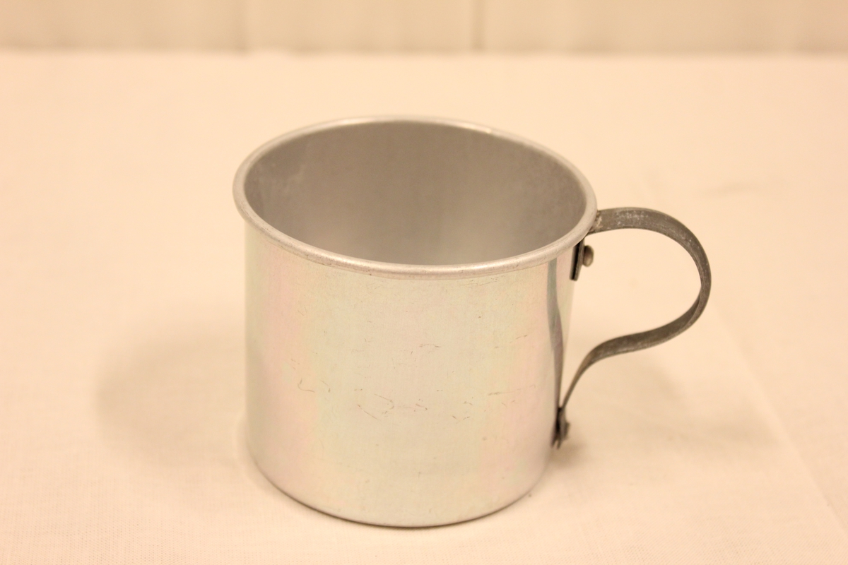 En kopp i aluminium med hank.