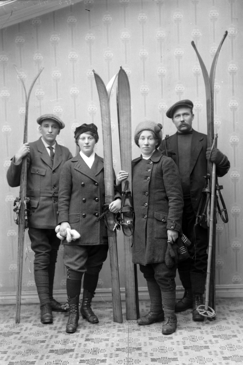 Gruppeportrett av fire personer med ski.
