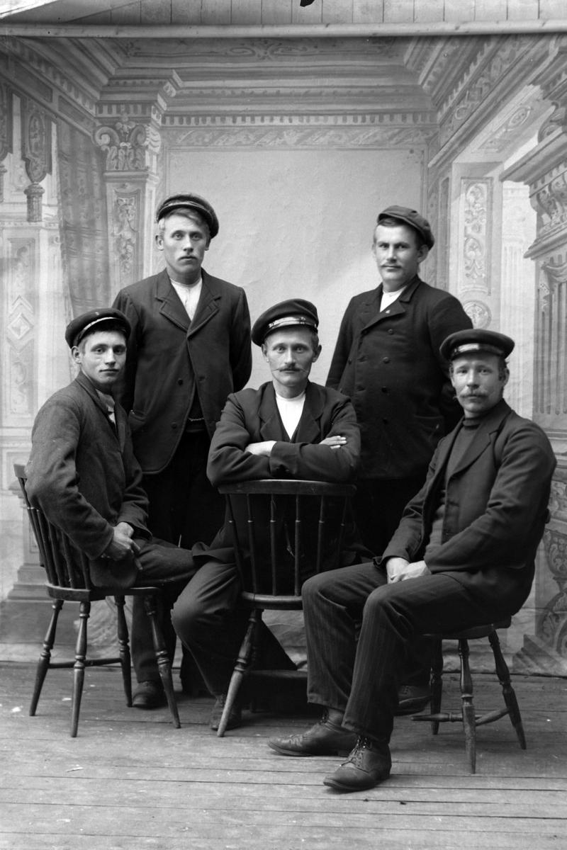 Studioportrett av fem menn med kasjettluer på hodet.