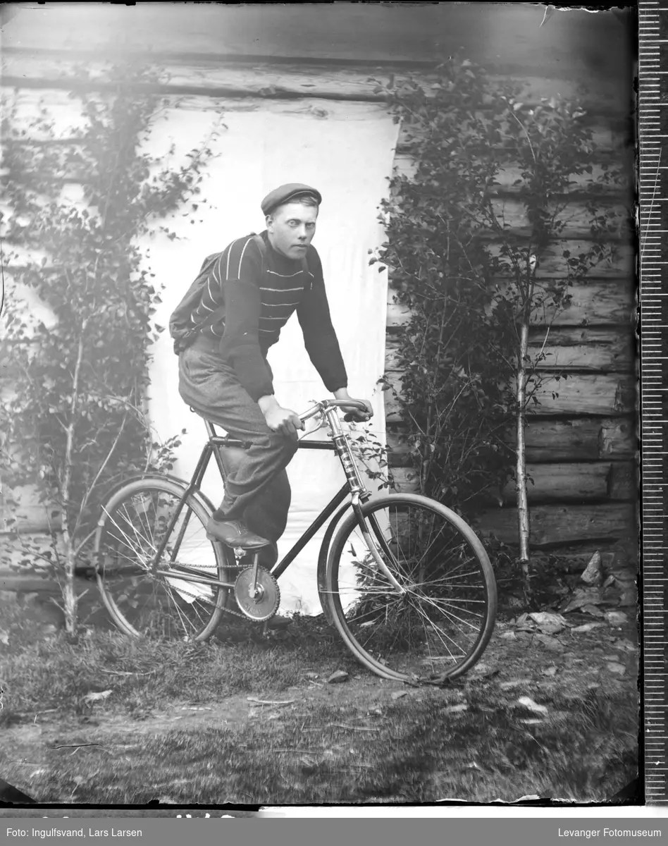 Portrett av en ung mann med ryggsekk på sykkel.