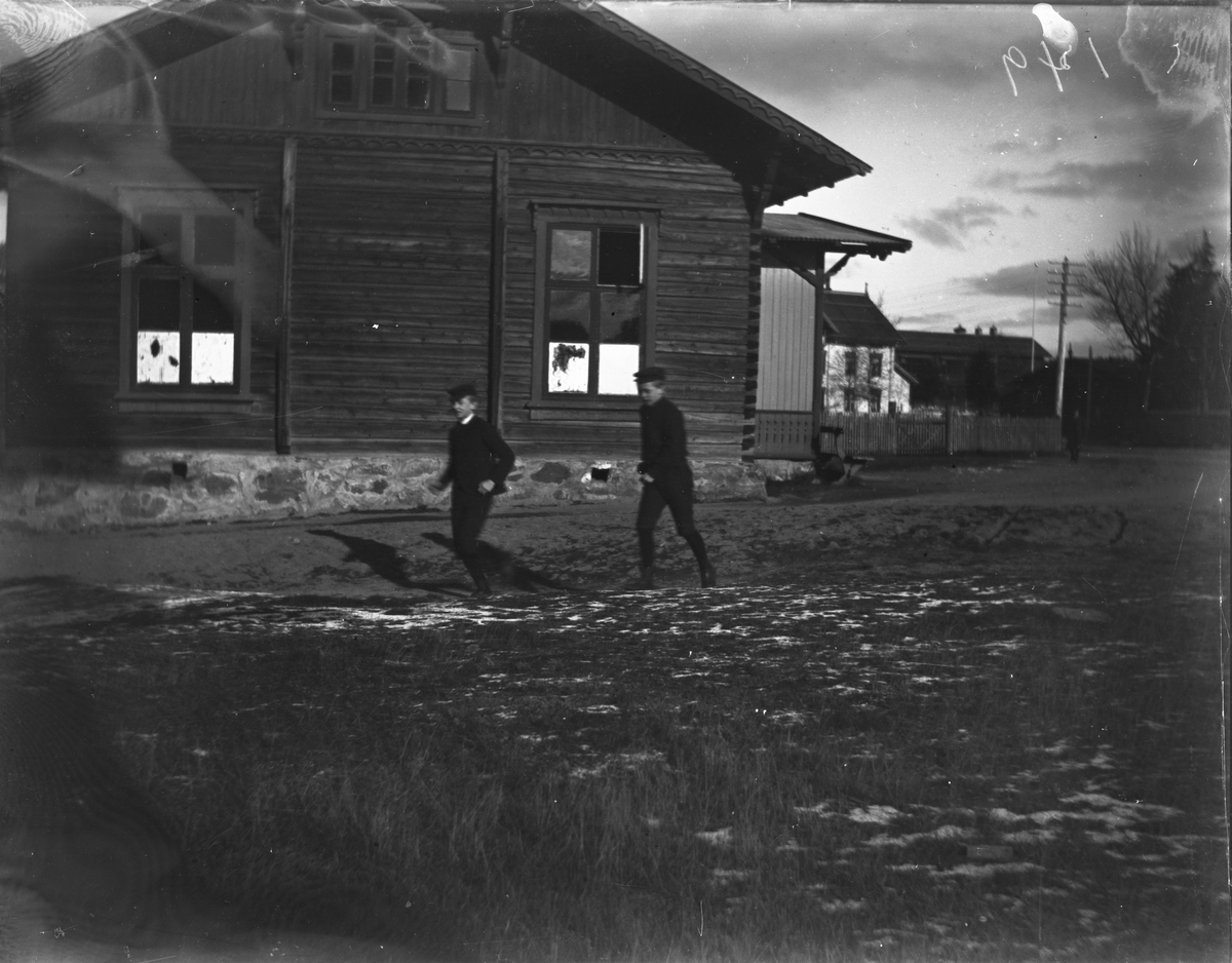 Stor tømmerbygning (neppe i Kragerø), to gutter utenfor