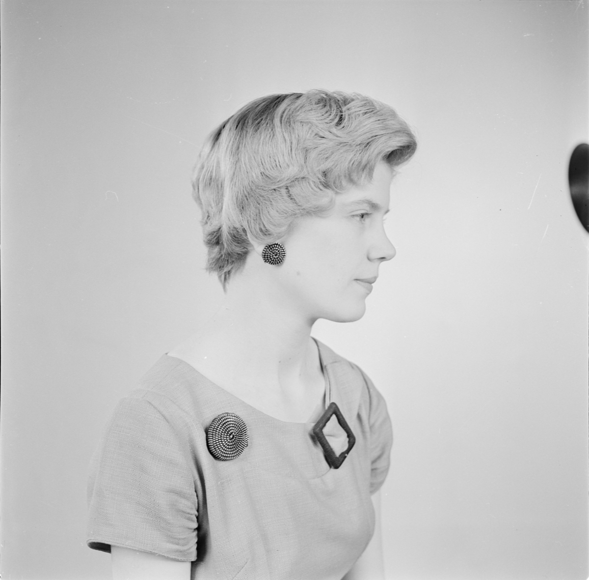 Kvinna med brosch och örhängen, Uppsala 1956