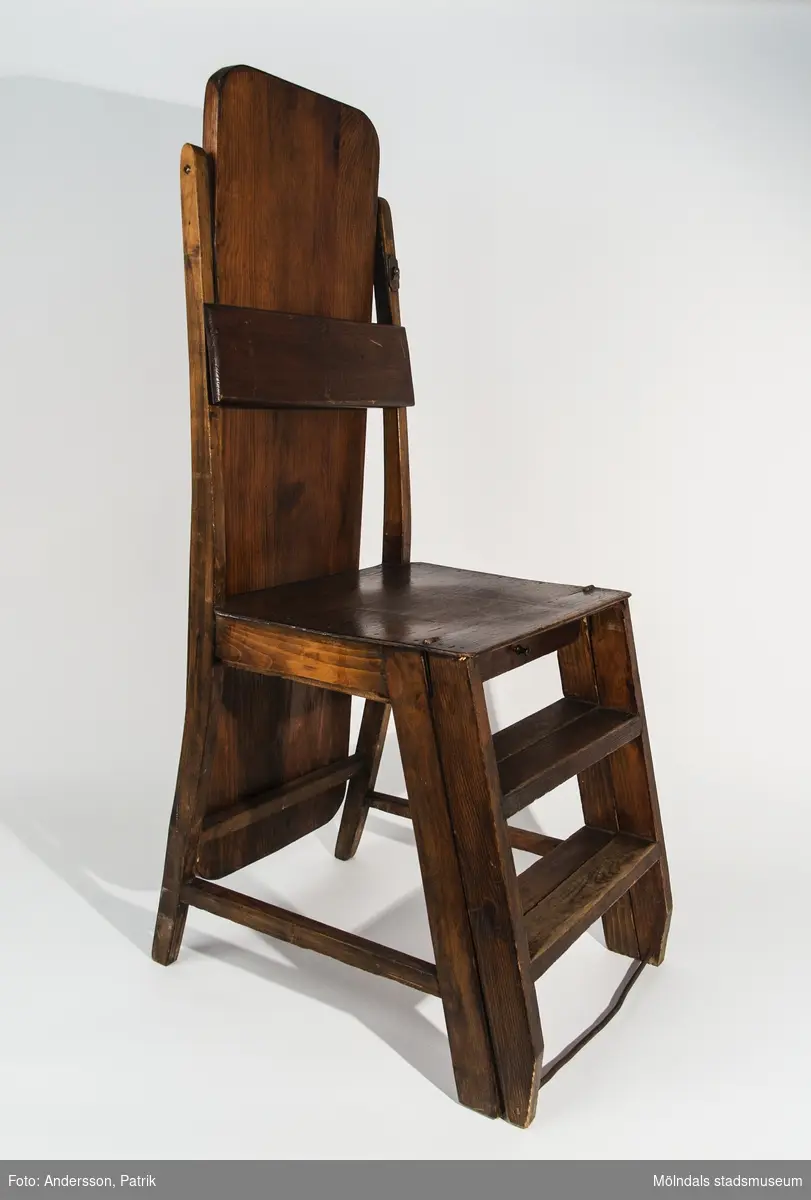 Strykbräda kombinerad med trappstege/stol. I ihopfällt läge är brädan vertikalställd och utgör rygg till stolen. I utfällt läge är trappstegen uppvikt som stödben för brädan. Under stolsitsen finns en liten förvaringslåda.
Mått utfälld: höjd 92 cm, längd 93 cm, bredd 38 cm