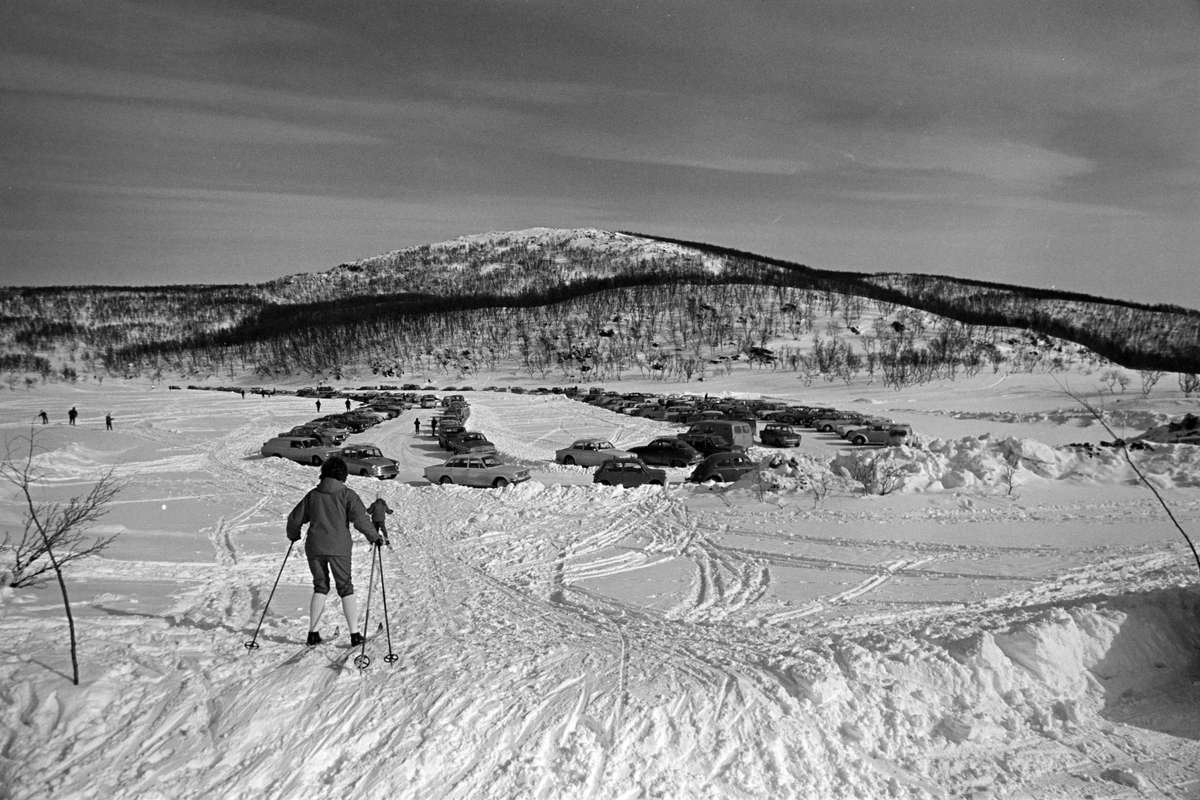Parkeringsplass på Aunfjellet, kvinne på ski i forgrunnen.