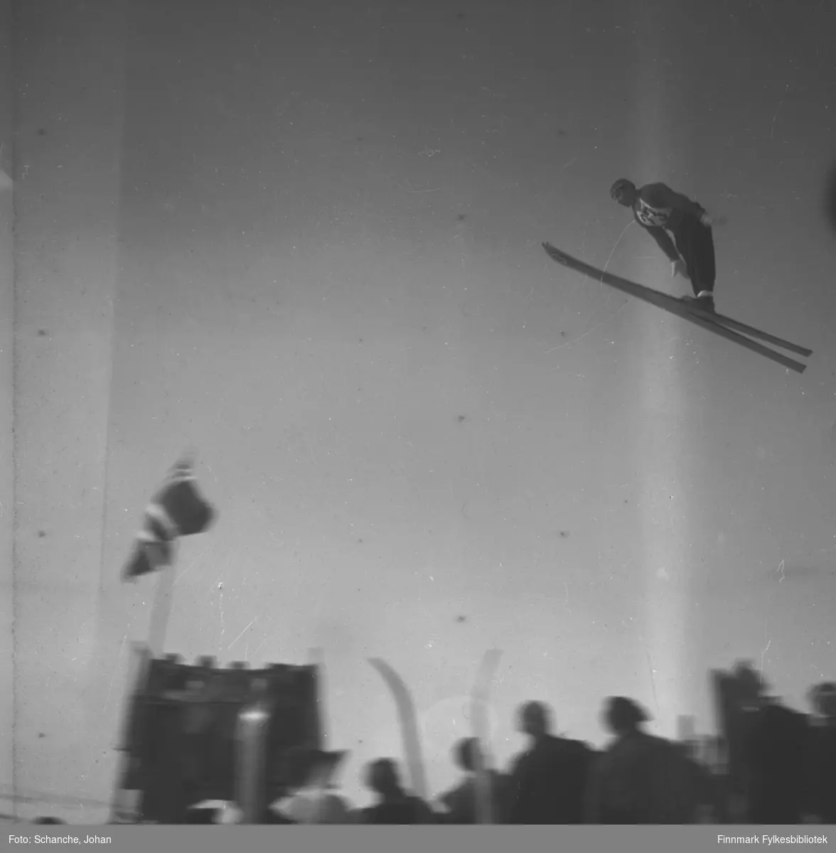 Kretsrennet på ski , Vadsø 1946. Harald Thunstad, Kirkenes hopper. Det står folk i bakken.