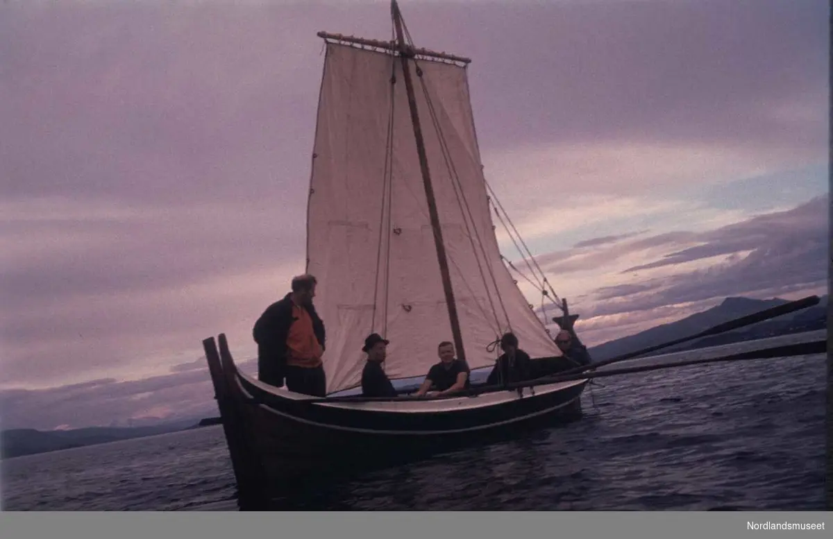 4 1/2 roms nordlandsbåt ved Bodøsjøen. Råseil. Flere personer ombord.
