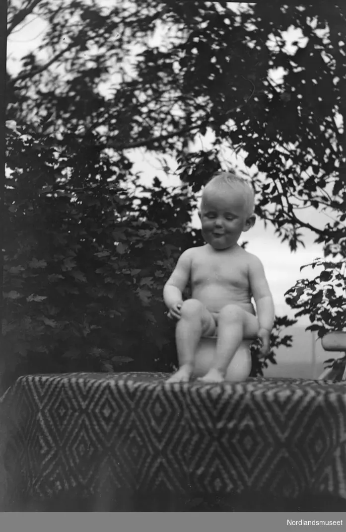 Portrett, Unni Strand, sitter på ei potte oppe på et bord.