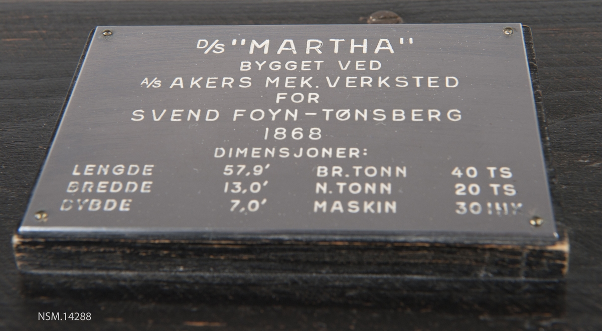 Enkel helmodell (sjømannsmodell) av hvalbåt i monter. Grønt skrog, mast, skorstein, 2 lettbåter, hvalkanon.