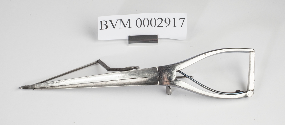 Kombinert instrument i stål for kutting og åpning. Ligner på ei tang men har i tillegg en kniv som kan føres opp ved hjelp av en sleide.