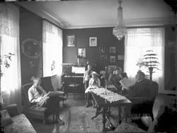 Familiebilde, mor, far og tre barn i stue