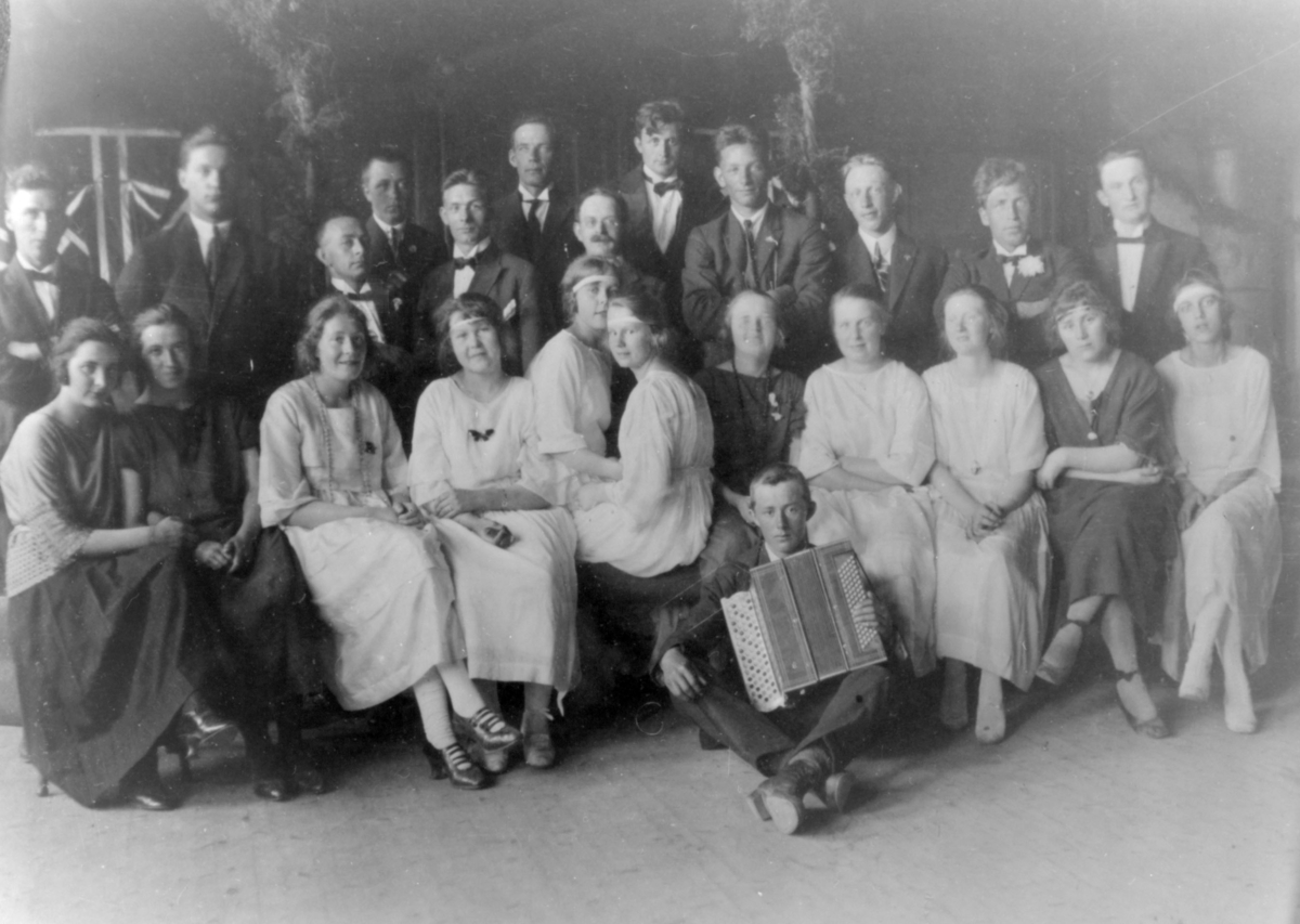 Leikaringen i Kirkenes, 1923. Gruppebilde med 24 menn og kvinner, ingen av dem er navngitt. Bildet er nok tatt i for- bindelse med en forestilling. Flere av kvinnene er kledt i hvite kjoler, og mennene i dress. En mann med trekkspill sitter fremst.