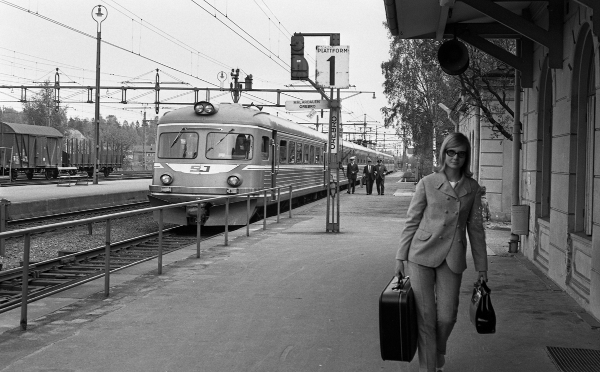 Frövi 2 juni 1967

Frövi järnvägsstation. 
Kvinnan på bilden är journalisten Lalli Svedling, uppvuxen i Vedevåg. Hon arbetade på Nerikes Allehanda en period.