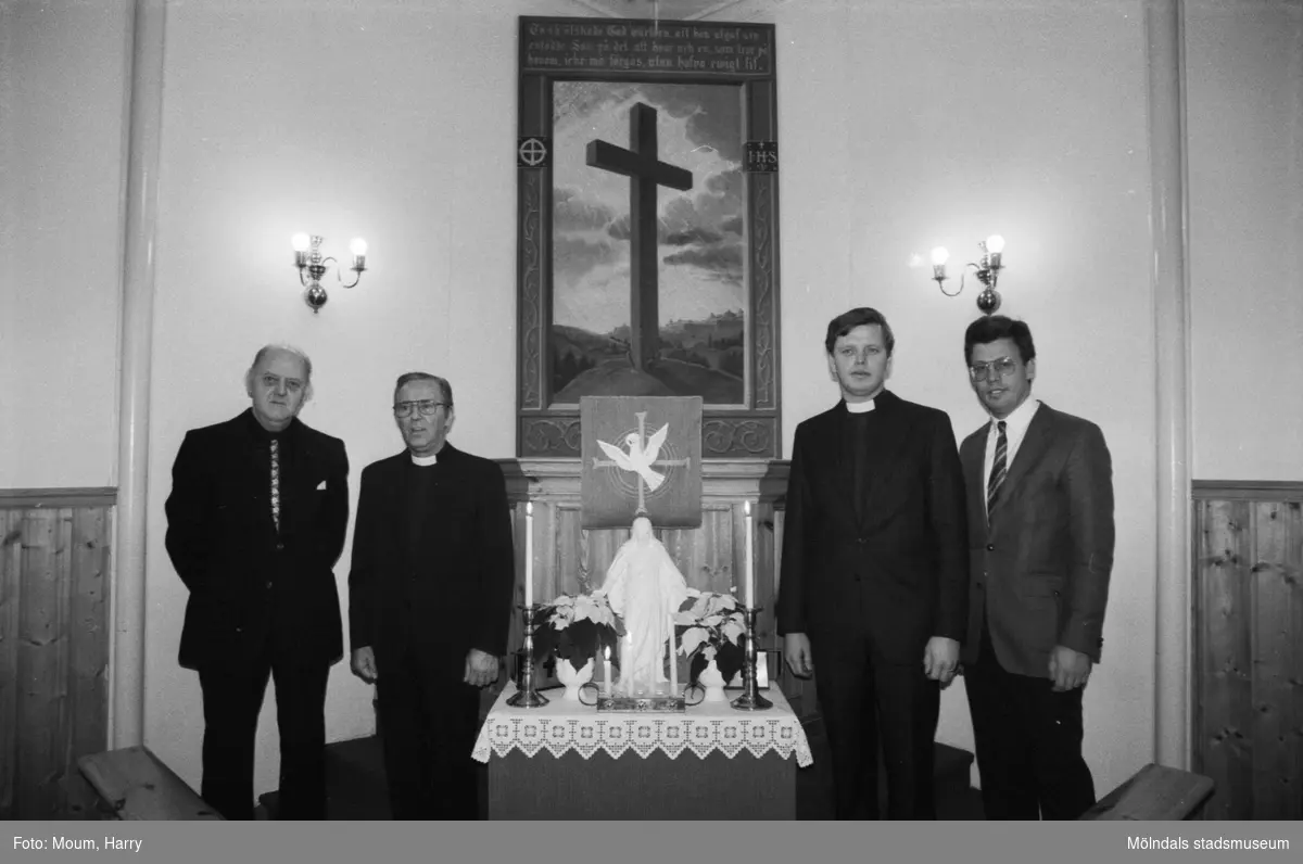 Greggered kapell i Lindome, år 1983. Pastorerna Gustaf Carlstedt och Anders Svensson tillsammans med två andra herrar framför kapellets altartavla.

För mer information om bilden se under tilläggsinformation.