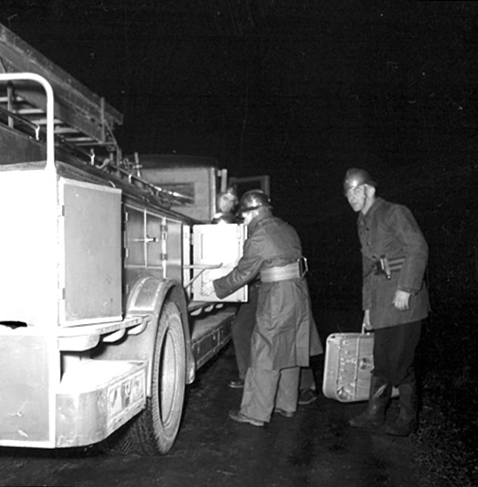 Brandkåren i Ställdalen, brandsläckningsarbete, brandmän.
Brandmannen till höger med väskan i handen är Sven Johansson.