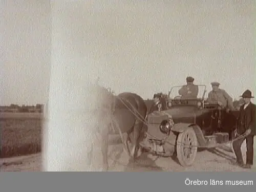 Tre herrar. Hästar framför bil. 
Bilen är en Scania-Vabis från 1912-13. Den hade reg.nr. T55 och ägdes av AB Joh. Thermaenius & Son.