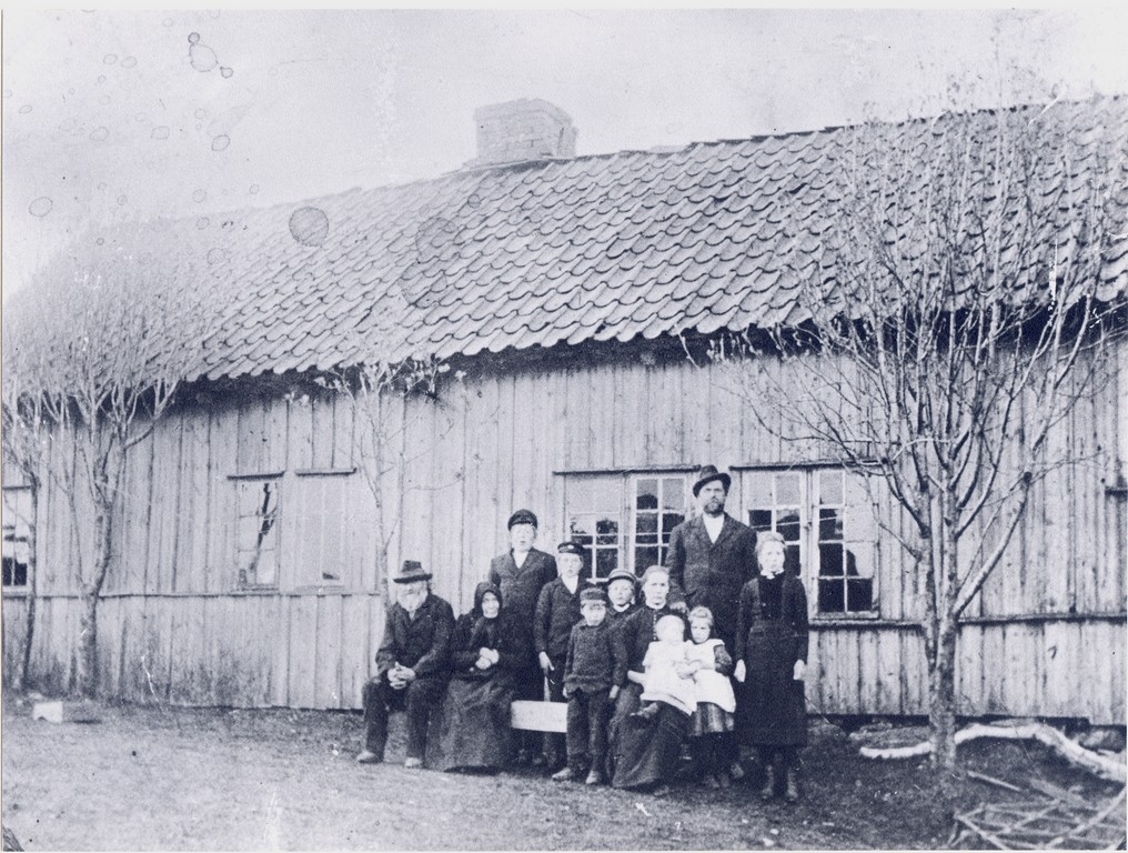 Tre generasjonar samla utanfot stovehuset på Kartavoll i 1903. Huset vart rive kort tid etter. Frå venstre Ole Olson Tjåland (1826 - 1909), kona Malli Jorina Johannesdtr. Kyllingstad i Gjesdal, (1828 - 1906), Ola , f. 1899, han vart bonde på farsgarden, Torvald f. 1893, han vart gift med Ingeborg Kristine Egeland, f. 1893, Sem f. 1897, han vart bonde på Ree og gift med Gurina Bruseli, f. 1896, Olav f. 1895, han vart bonde på Auglend og gift med Elisa Jansdtr. Bruseli f. 1895, mora Karen Toresdtr. frå Ånestad i Varhaug (1866 - 1946), på fanget Klara f. 1902, ho vart gift med Ola Ivarson Topdal f. 1896 i Ogna, Malena f. 1899, ho vart gift med Ommund Olson Tu f. 1888 i Klepp, far Ole Olson Bergene, ståande med hatt, f. 1866, lengst til høgre Maria f. 1891