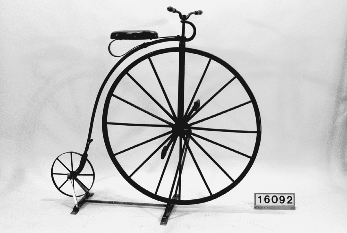 Cykel med bakhjul av järn och framhjul av trä. Framhjulet med dekorerade ekrar. Cykeln är troligen ett hemmabygge.