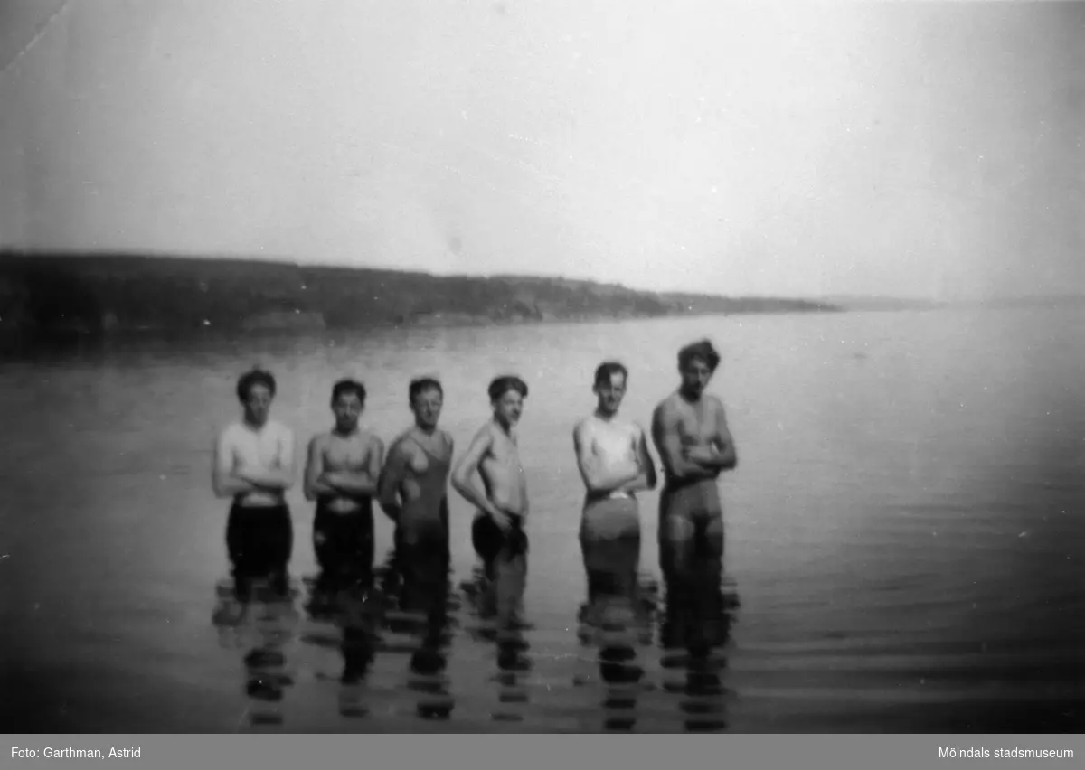 Sex unga män står i vattnet i sjön Lygnern, 1930- 40-tal. Från vänster: okänd, Gösta Gunnarsson, Helmer Garthman samt okända till höger.