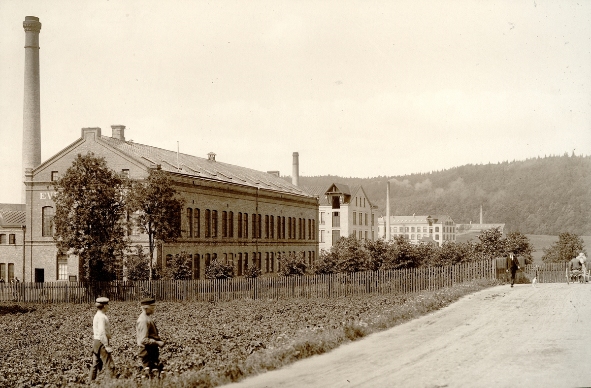 Evedahls fabrik längst till vänster, sedan följer de s.k. norska fabrikerna Pedersen och Decker, Klädningstygsfabriken och Band-och Hängslefabriken.
Med fotografiet kom fotografen på fjärde plats i Svenska Tusristföreningens Pristäflan 1902.