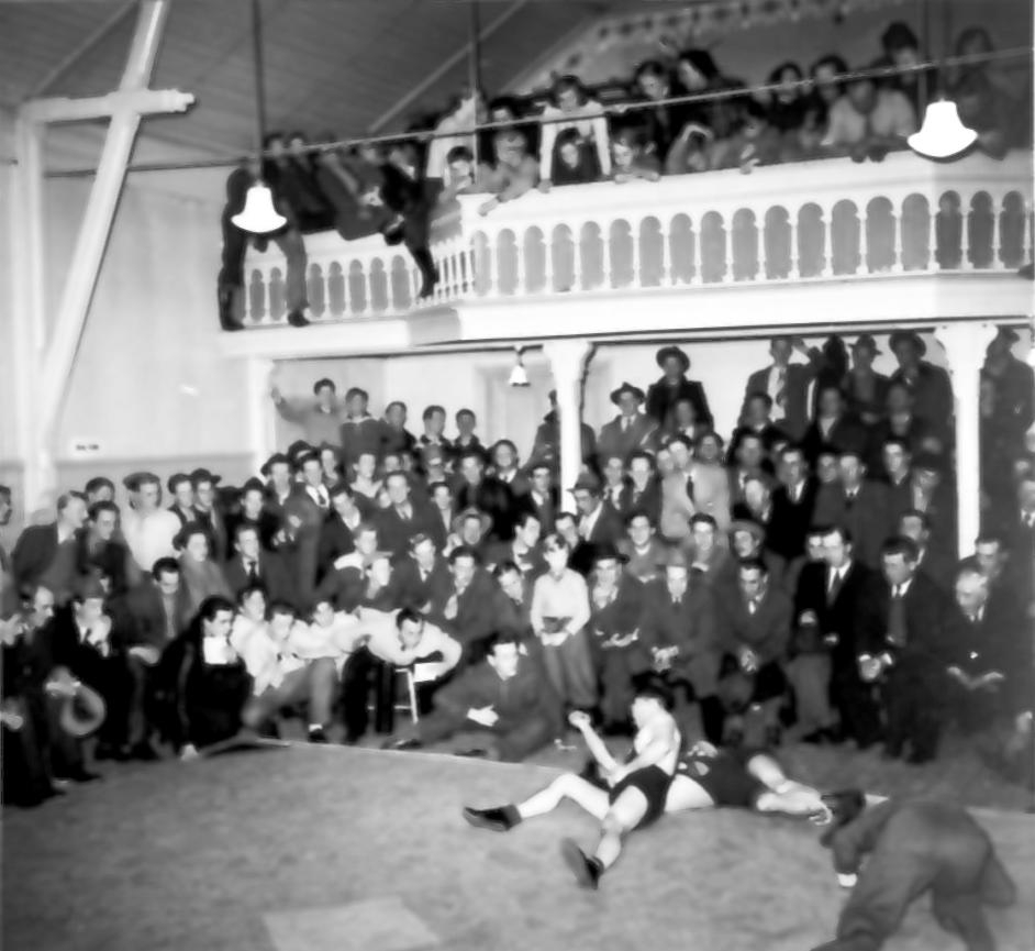 "Medan vi vänta på idrottshall".
Brottningsmatch på Sigurds lokal. Från utställningen "Falköping i bild" 1952.